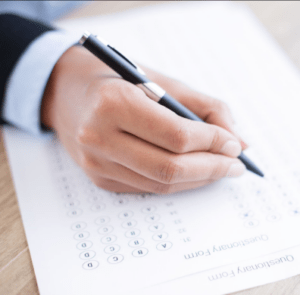 a hand holding a pen over a paper